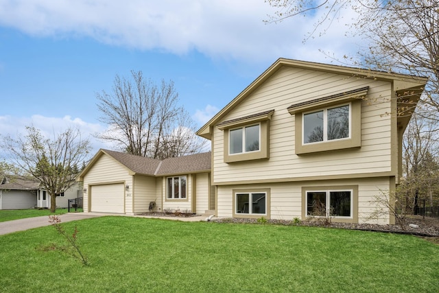 tri-level home with an attached garage, driveway, and a front yard
