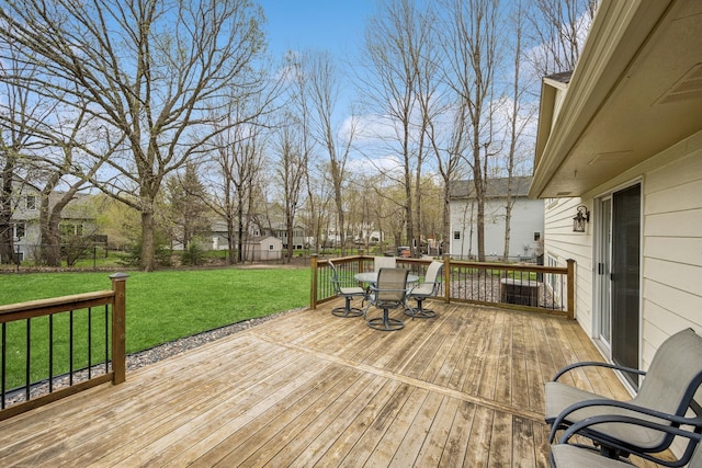 wooden terrace with a yard, outdoor dining area, and a fenced backyard