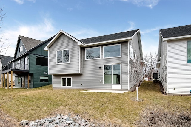 rear view of house with a yard and central air condition unit