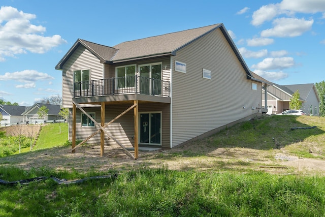 rear view of property with a wooden deck and a lawn