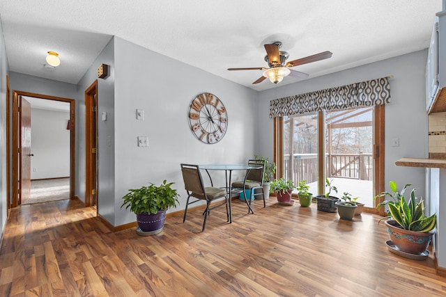 sitting room featuring ceiling fan, hardwood / wood-style floors, and a textured ceiling