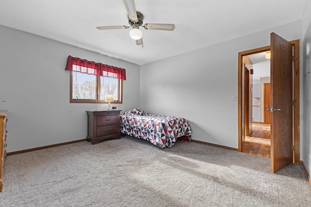 carpeted bedroom featuring ceiling fan and a textured ceiling