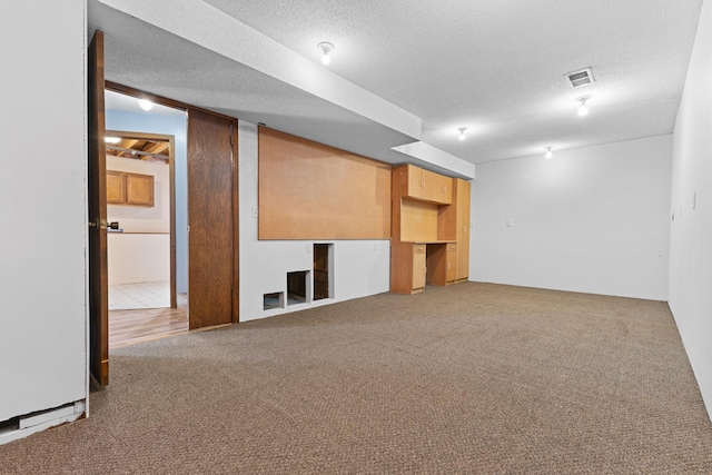 basement with carpet flooring and a textured ceiling