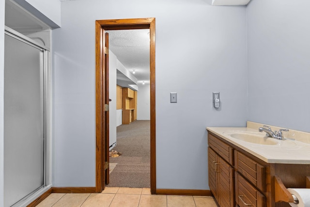 bathroom with vanity, tile patterned flooring, a shower with door, and a textured ceiling