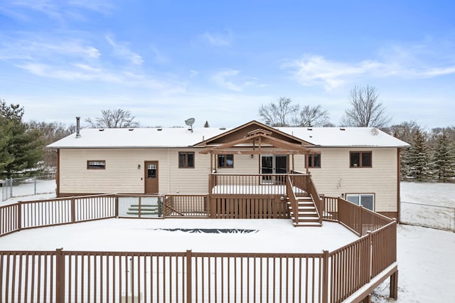 snow covered house with a wooden deck