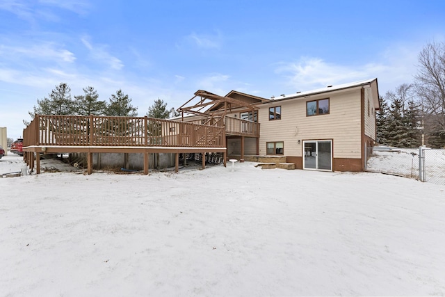 snow covered house with a wooden deck