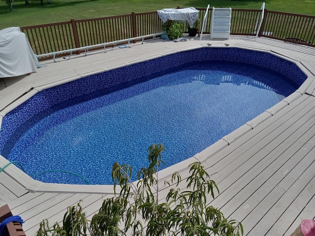 view of pool featuring a wooden deck and a yard