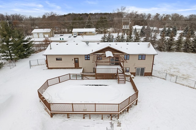 snow covered rear of property with a deck