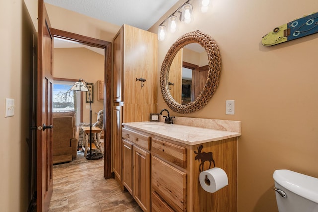 bathroom featuring toilet, a textured ceiling, and vanity