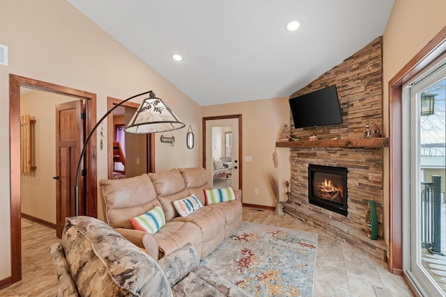 living room with lofted ceiling and a stone fireplace