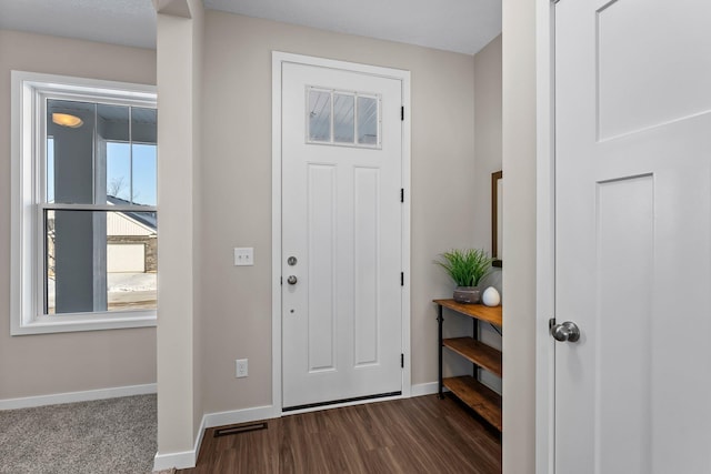 entrance foyer featuring dark wood-type flooring and plenty of natural light