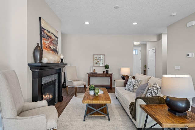 living room with a textured ceiling and light wood-type flooring