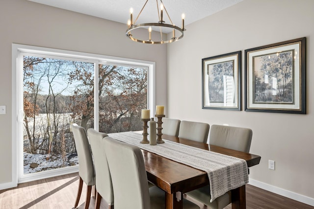 dining space featuring a textured ceiling, a chandelier, dark hardwood / wood-style floors, and a healthy amount of sunlight