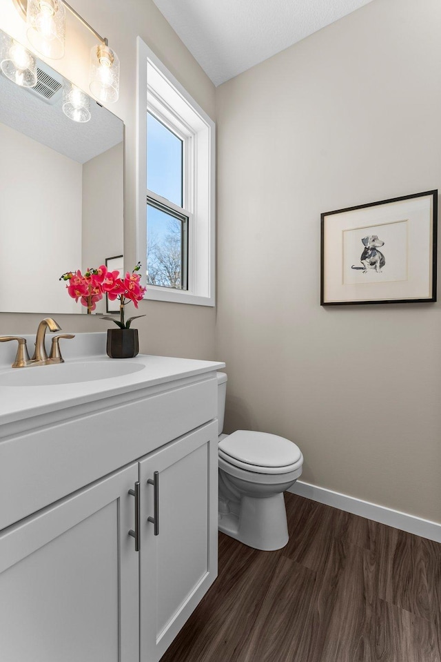 bathroom with vanity, wood-type flooring, and toilet