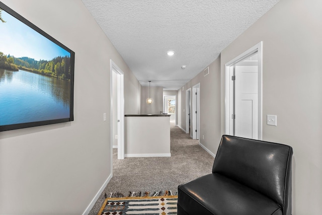 corridor featuring carpet and a textured ceiling