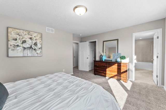 carpeted bedroom featuring connected bathroom and a textured ceiling