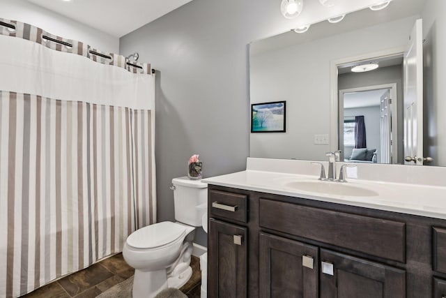 bathroom featuring vanity, toilet, and walk in shower