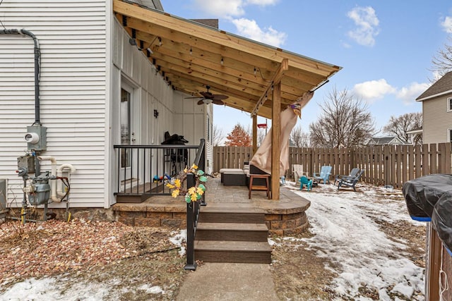 snow covered deck featuring ceiling fan and a fire pit