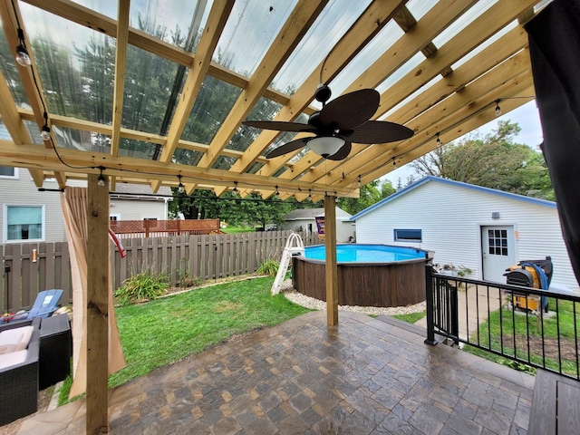 view of patio / terrace with ceiling fan and a fenced in pool