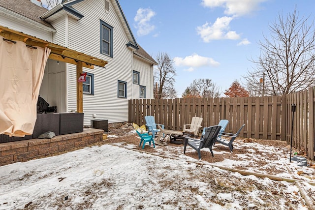 snow covered patio featuring an outdoor fire pit