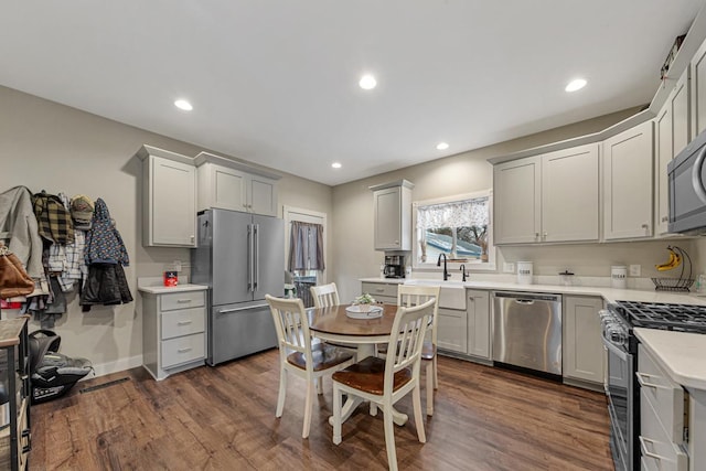 kitchen with sink, dark hardwood / wood-style flooring, stainless steel appliances, and gray cabinetry