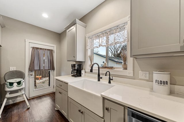 kitchen with dark wood-type flooring, sink, and stainless steel dishwasher