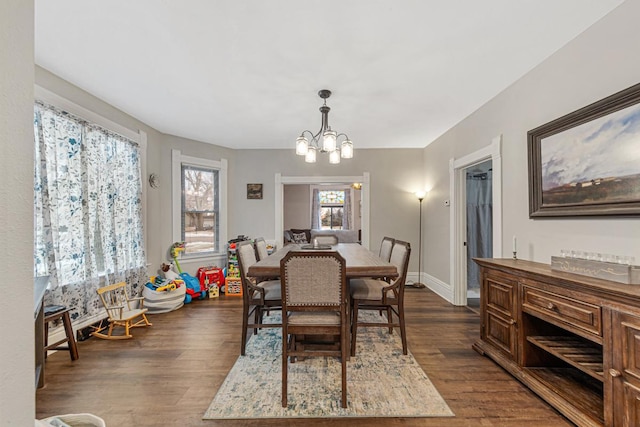 dining room featuring dark hardwood / wood-style floors and an inviting chandelier