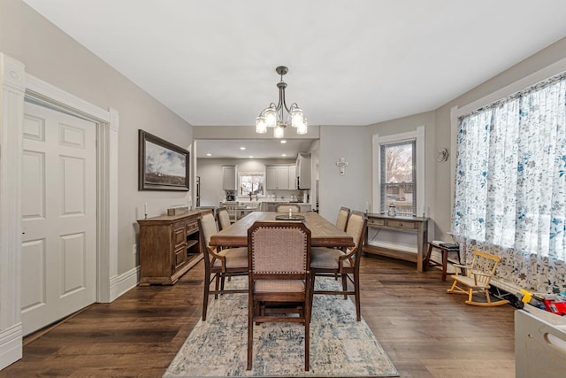 dining space with dark hardwood / wood-style floors and a notable chandelier