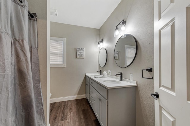 bathroom with toilet, wood-type flooring, and vanity