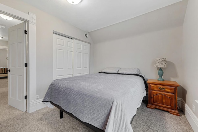 carpeted bedroom featuring a closet and lofted ceiling