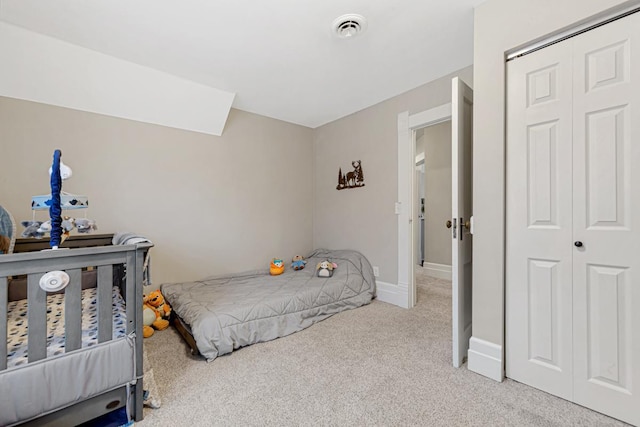 bedroom featuring light carpet and a closet