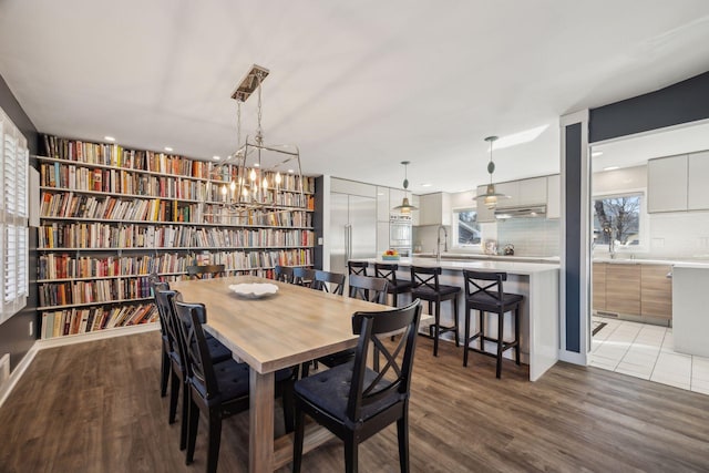 dining space with sink and wood-type flooring