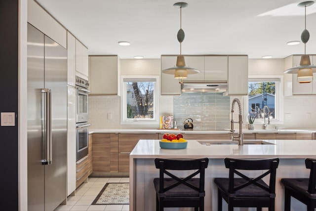 kitchen featuring pendant lighting, stainless steel appliances, sink, and a breakfast bar area