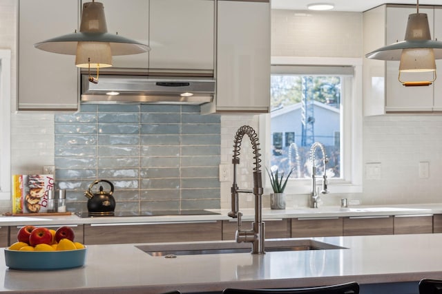 kitchen with white cabinetry, sink, decorative light fixtures, and decorative backsplash