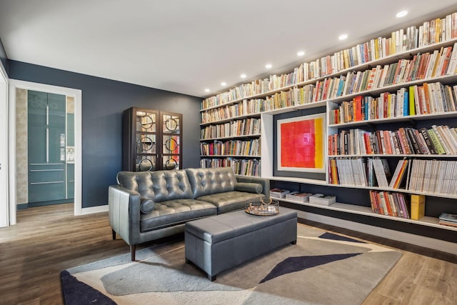 sitting room featuring hardwood / wood-style flooring and built in shelves