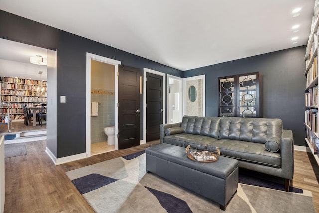 living room with hardwood / wood-style floors and tile walls