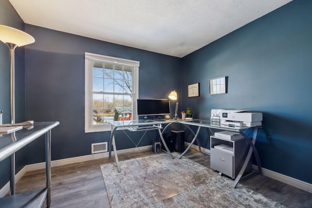 office with a textured ceiling and dark hardwood / wood-style flooring