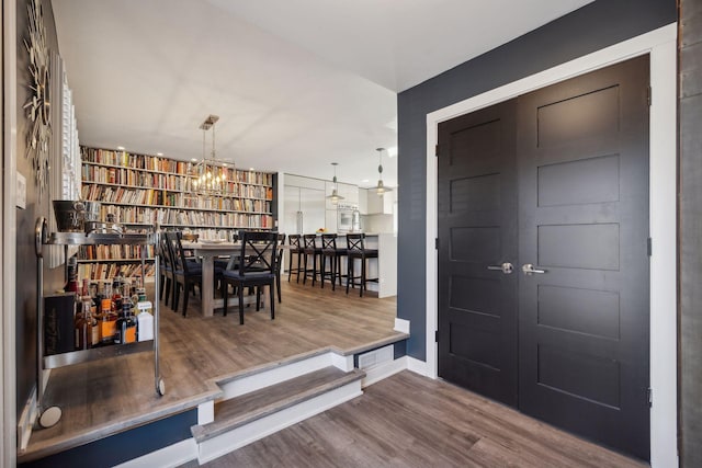 foyer featuring wood-type flooring and a chandelier