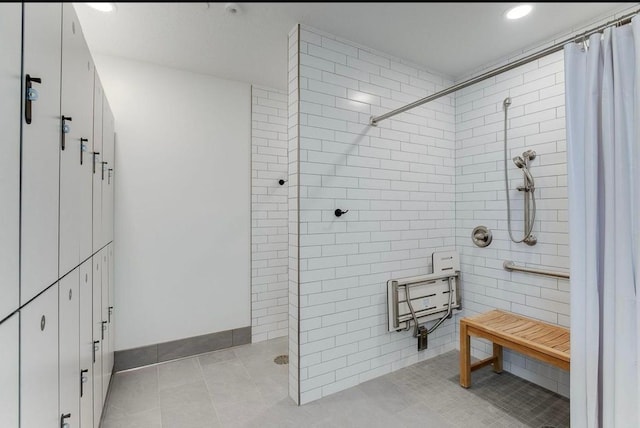 bathroom with tiled shower, tile patterned floors, and tile walls