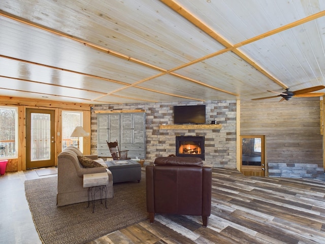 living room with wooden ceiling, wooden walls, ceiling fan, a brick fireplace, and dark hardwood / wood-style flooring