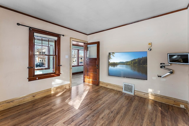 empty room featuring hardwood / wood-style flooring and crown molding