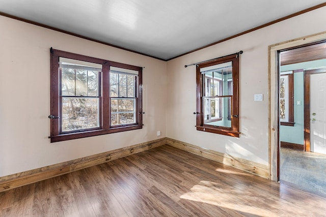 unfurnished room with hardwood / wood-style floors and crown molding