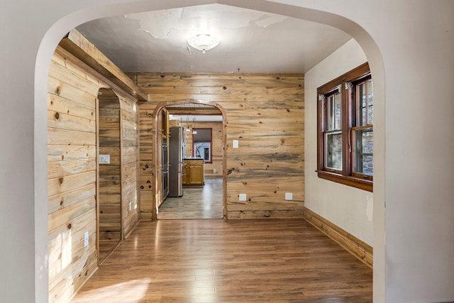 hall with wood-type flooring and wooden walls