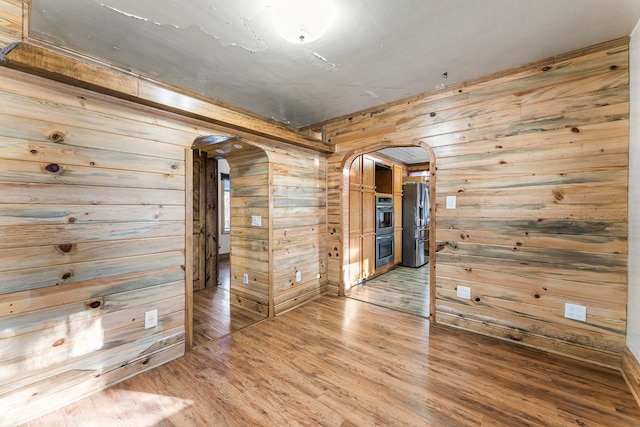 empty room featuring hardwood / wood-style flooring and wood walls