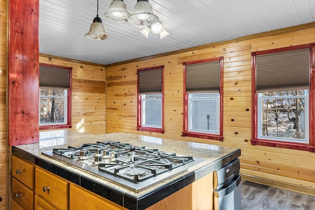 kitchen with wood walls, dark wood-type flooring, stainless steel gas cooktop, and wood ceiling