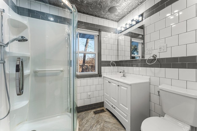 bathroom featuring tile walls, an enclosed shower, vanity, and toilet