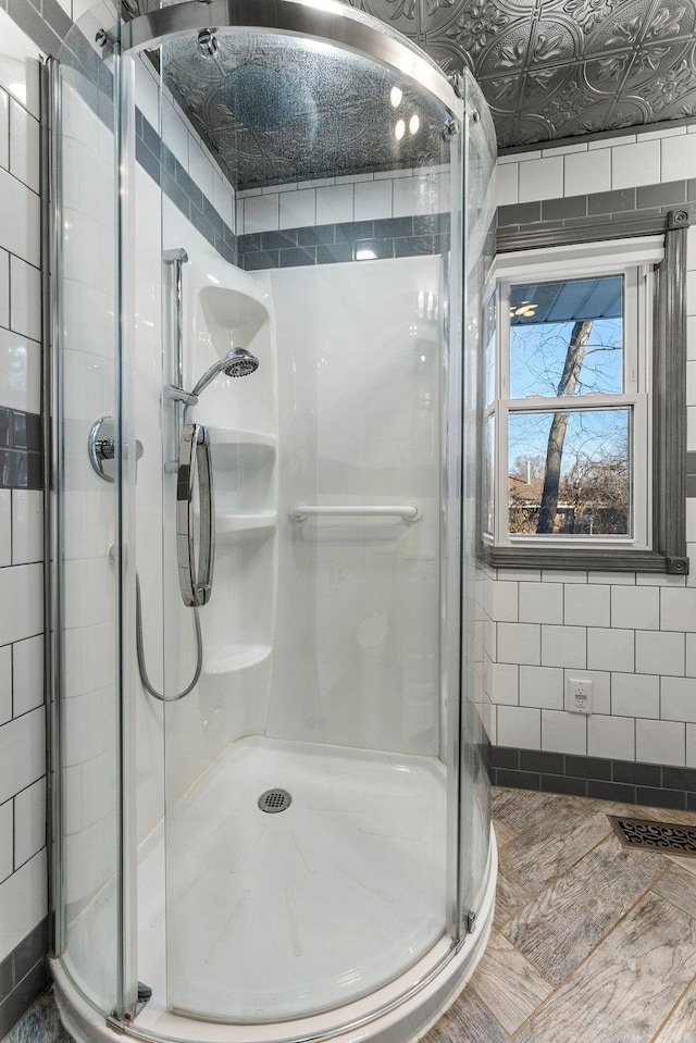 bathroom with a shower with shower door and tile walls