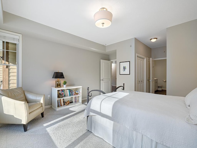 bedroom featuring ensuite bath, carpet flooring, and baseboards