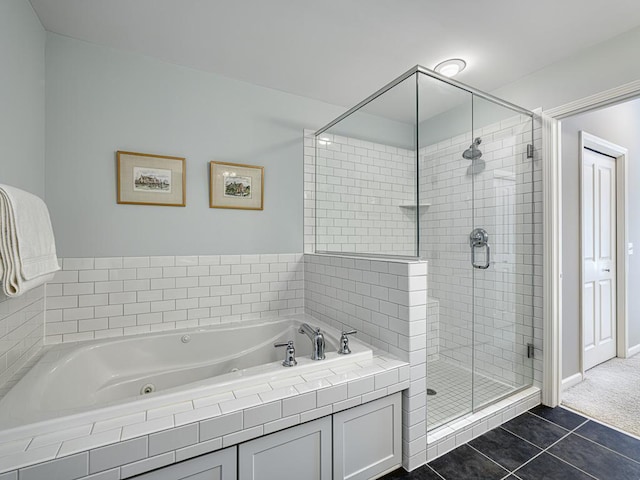 bathroom with a stall shower, tile patterned flooring, baseboards, and a bath