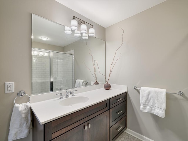 bathroom with a shower stall, vanity, and baseboards